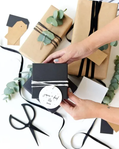 Vista 4 de The Cotton & Canvas Co. Adorno personalizado de cerámica de cerámica para bodas con nombres y fecha, con cinta y caja de regalo de cortesía