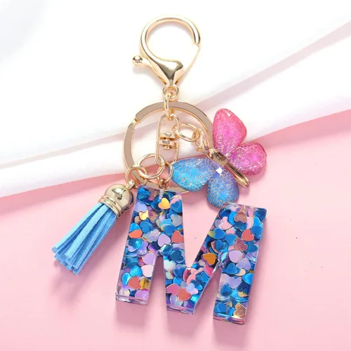 Vista 2 de OKAICEN Llavero de letra inicial del alfabeto de moda, borla y mariposa, llavero para bolso, bolsos de mano para mujeres y niñas
