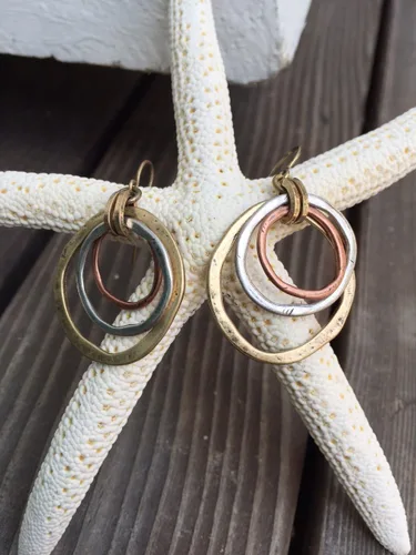 Vista 5 de Aretes de amanecer, artesanales, con diseño de círculos bruñidos, bañados en cobre, bronce, y plata.