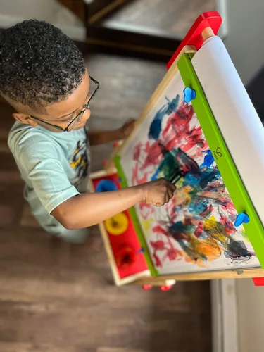 Vista 3 de Caballete de madera para niños con rollo de papel y accesorios Hape All-in-One