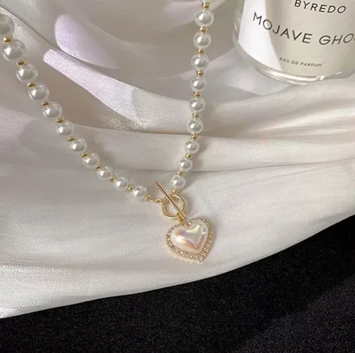 Vista 4 de Collar de perlas y corazón para mujer. Diseño de corazón de cristal con perlas blancas artificiales. Ideal para bodas, fiestas o uso casual.