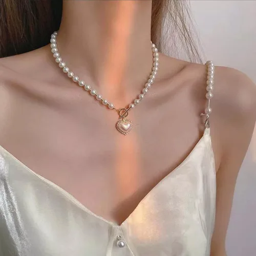 Vista 2 de Collar de perlas y corazón para mujer. Diseño de corazón de cristal con perlas blancas artificiales. Ideal para bodas, fiestas o uso casual.