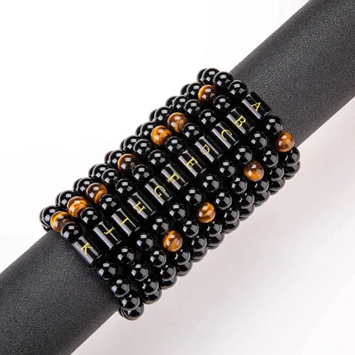 Vista 5 de Brazalete hecho a mano con letra inicial del nombre, las cuentas son de ónix negro u ojo de tigre, la cuerda es trenzada, un brazalete lleno