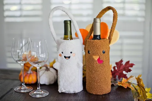 Vista 10 de Pearhead Soporte para botella de vino fantasma de Halloween, bolsa de regalo reutilizable de sherpa de felpa con cara sonriente y asa - Lindo regalo