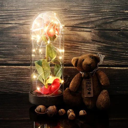Vista 2 de CVHOMEDECO. Funciona con pilas con temporizador LED iluminado y rosa de poliuretano roja con pétalos caídos en una cúpula de cristal, gran regalo