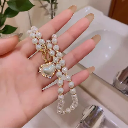 Vista 8 de Collar de perlas y corazón para mujer. Diseño de corazón de cristal con perlas blancas artificiales. Ideal para bodas, fiestas o uso casual.