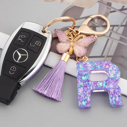 Vista 2 de Suweibuke Coloridos llaveros con letras iniciales para mujeres y niñas con borla de mariposa, dije para bolso, bolsos, mochilas