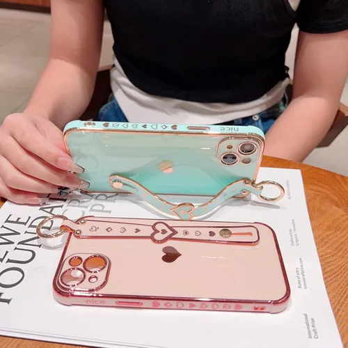 Vista 2 de Lindo corazón de amor para niñas mujeres lujo chapado borde parachoques suave TPU a prueba de golpes caso con soporte de pulsera para iPhone Negro