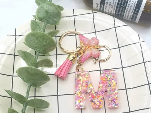 Vista 5 de Meefisher Llavero de letra inicial de mariposa con borla rosa púrpura y estrella, para cartera, monederos, mochila, bolsos, alfabeto, llavero