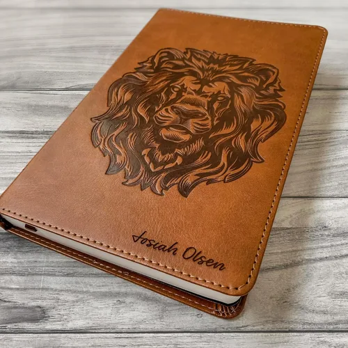 Vista 3 de Biblia ESV personalizada, marrón con un león en la portada, opción para personalizar con el nombre con letra a mano en la portada