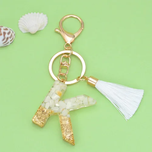 Vista 2 de Suweibuke Lindos llaveros beige para mujeres y niñas, llaveros con letras iniciales con borla blanca, dijes para mochila y bolso de mano