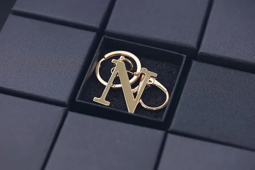 Vista 5 de Llavero de letra A-Z dorado para mujeres y hombres, bolso de mano de metal con letra inicial del alfabeto