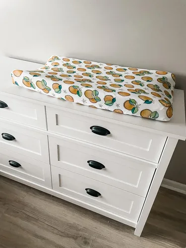 Vista 3 de Funda ajustable para cambiador de flores de naranja, hecha de viscosa de bambú y elastano, se adapta a cambiador estándar, por Florida Kid Co.