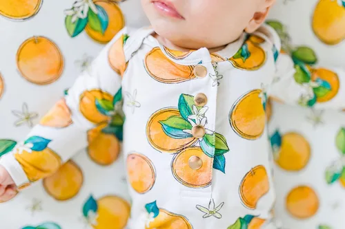 Vista 5 de Funda ajustable para cambiador de flores de naranja, hecha de viscosa de bambú y elastano, se adapta a cambiador estándar, por Florida Kid Co.