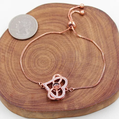 Vista 4 de Pulsera ajustable de cadena de plata/oro rosa, 4 dijes de corazón diferentes en 100 idiomas con texto en inglés "Say I Love You", pulsera