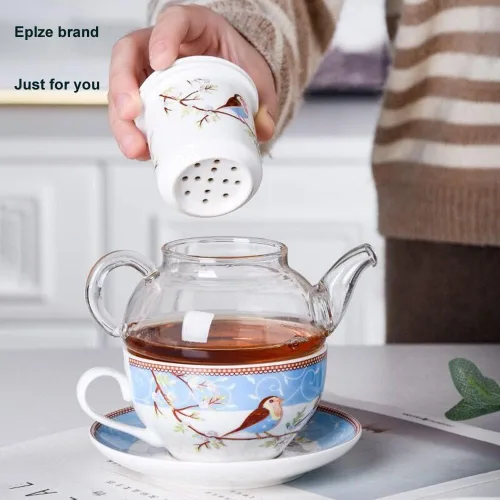 Vista 2 de Juego de té para uno, tetera de vidrio con infusor de porcelana y colador y taza y platillo, patrón de pájaro feliz (azul)