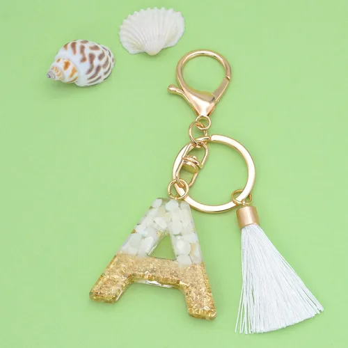 Vista 2 de Suweibuke Lindos llaveros beige para mujeres y niñas, llaveros con letras iniciales con borla blanca, dijes para mochila y bolso de mano