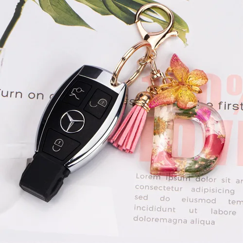 Vista 3 de Lindos llaveros para mujeres y niñas, llaveros de letra inicial con borla de mariposa, dije para bolso, mochilas, bolsos de mano