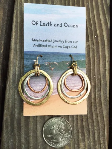 Vista 3 de Aretes de amanecer, artesanales, con diseño de círculos bruñidos, bañados en cobre, bronce, y plata.