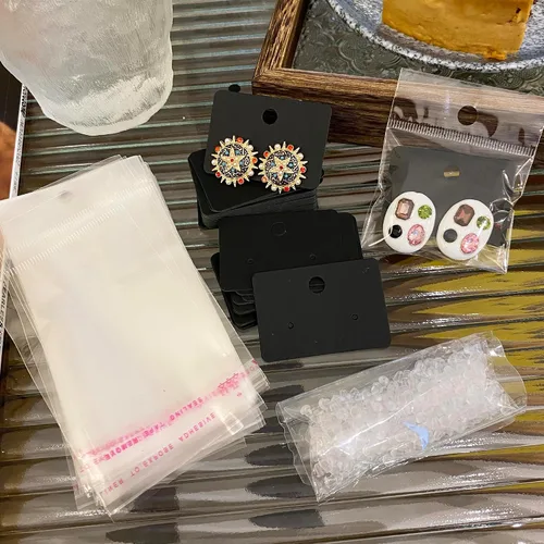 Vista 5 de Femtindo Tarjetas de exhibición de aretes con 100 tarjetas de aretes, 200 piezas de parte trasera de aretes y 100 bolsas autosellantes para venta