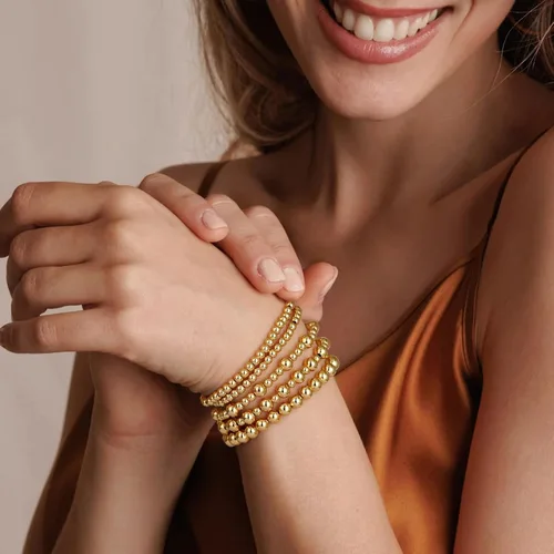 Vista 2 de adoyi - Pulseras de oro para mujer, impermeables, con cuentas de bolas chapadas en oro de 14K, pulseras ajustables apilables para regalos