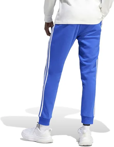 Vista 2 de adidas Pantalones Essentials de forro polar con puños cónicos de 3 rayas para hombre, Azul semi lúcido