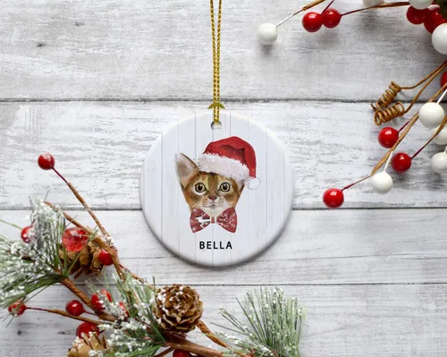 Vista 3 de Andaz Press Adorno redondo personalizado de cerámica para árbol de Navidad, abisinio, corona de acebo, sombrero de Papá Noel, con gráfico de gato