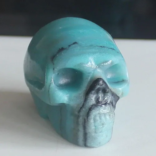 Vista 2 de Figura de calavera de piedras preciosas mixtas tallada a mano de 2 pulgadas para decoración del hogar (Amazonita)