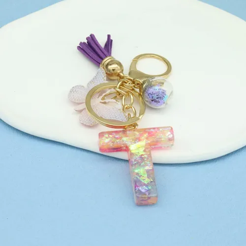 Vista 3 de Llaveros con letras iniciales para mujeres y niñas, mochila con resinas, letras del alfabeto, llaveros de coche, bola de mariposa, borla con dije