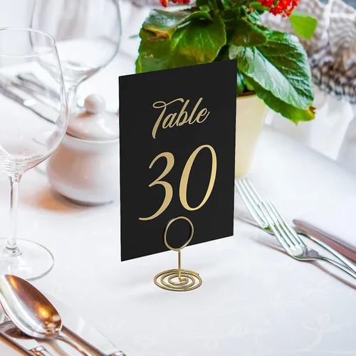 Vista 2 de Números de mesa negros del 1 al 30 con letras doradas y 30 soportes dorados para números de mesa