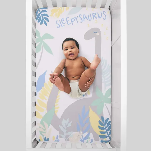 Vista 2 de NoJo Sleepysaurus - Sábana bajera ajustable para cuna, 100% algodón, diseño de hojas de dinosaurio azul, amarillo, gris y blanco