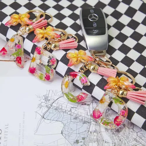 Vista 3 de HLQHXWHZT Llavero con letra inicial para mujer, llavero de mariposa, borla y mochila con flores realmente secas