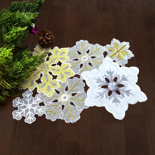Vista 3 de Grelucgo Juego de 4 manteles individuales bordados a máquina y cortados a mano con copos de nieve de invierno plateados y dorados para Navidad