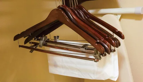Vista 4 de Percha curvada de madera con clips de cojín ajustables, caja de 100 perchas de madera de 17 pulgadas con acabado de nogal y gancho giratorio cromado