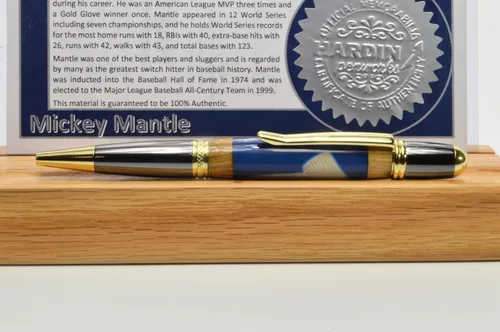 Vista 2 de Mickey Mantle Twist Pen titanio negro y titanio dorado está hecho con madera de los asientos de madera del Yankee Stadium y una muestra de un juego