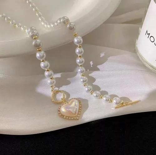 Vista 3 de Collar de perlas y corazón para mujer. Diseño de corazón de cristal con perlas blancas artificiales. Ideal para bodas, fiestas o uso casual.