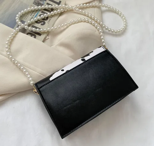 Vista 4 de Bolso cruzado de mano con correa de perlas y estampado de vaca