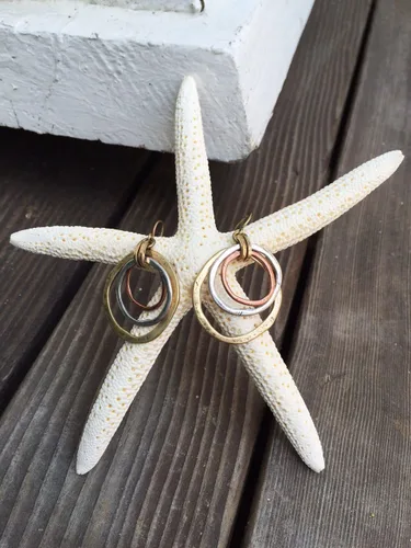 Vista 6 de Aretes de amanecer, artesanales, con diseño de círculos bruñidos, bañados en cobre, bronce, y plata.