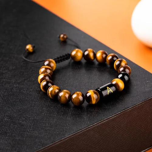 Vista 2 de FRG Brazalete con letra inicial del nombre, hecho a mano, las cuentas son de ónix negro u ojo de tigre, la cuerda es trenzada, un brazalete lleno