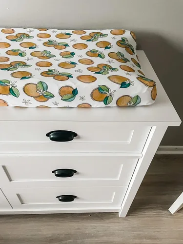 Vista 2 de Funda ajustable para cambiador de flores de naranja, hecha de viscosa de bambú y elastano, se adapta a cambiador estándar, por Florida Kid Co.