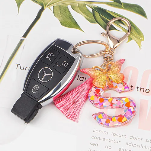 Vista 3 de Coloridos llaveros con letras iniciales para mujeres y niñas con borla de mariposa, dije para bolso, bolsos, mochilas