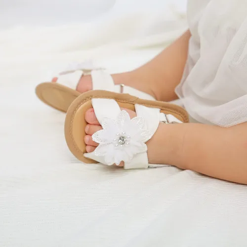 Vista 2 de GDSDYM Sandalias de verano para bebés y niñas con lazo de flores, suela suave, para vestido de boda, zapatos planos para recién nacidos, primeros