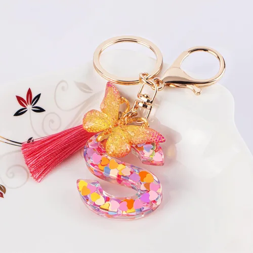 Vista 2 de Coloridos llaveros con letras iniciales para mujeres y niñas con borla de mariposa, dije para bolso, bolsos, mochilas