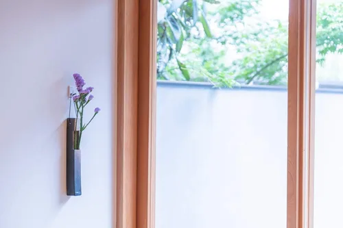 Vista 2 de Jarrón de pared de cerámica japonesa para un solo tallo, fabricado en Japón, diseño minimalista de Wabi-Sabi, acabado natural al horno, artículos